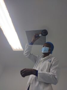 Industrial workers using a hoist system to carefully position a large heat exchanger within a precision testing tank at a manufacturing facility.