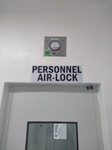 "Technicians in safety gear inspecting a large industrial heat exchanger inside a factory with precision instruments.