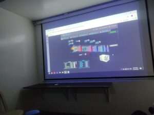 ndustrial workers monitoring the precise positioning of a heat exchanger using a hoist system in a factory setting.